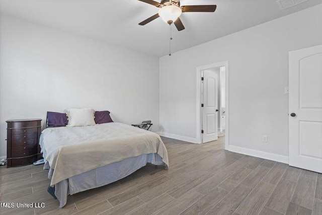 bedroom featuring a ceiling fan, visible vents, baseboards, and wood finished floors