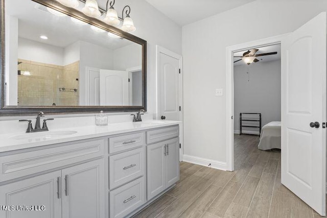 full bathroom featuring double vanity, wood tiled floor, a sink, and a shower stall