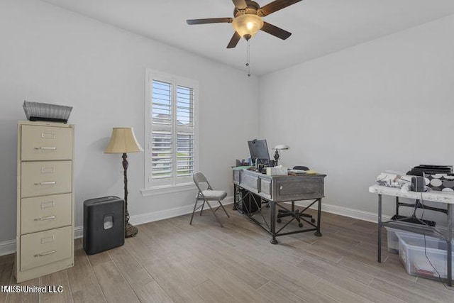 home office with a ceiling fan, baseboards, and wood finished floors