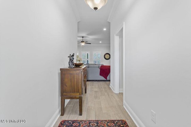 hallway with recessed lighting, baseboards, crown molding, and light wood finished floors