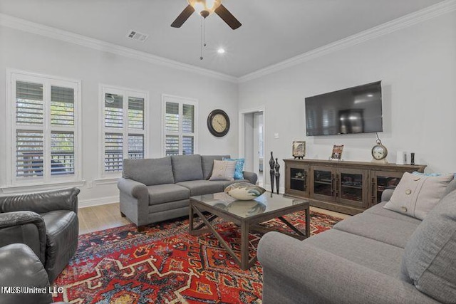 living room with visible vents, ornamental molding, ceiling fan, wood finished floors, and baseboards