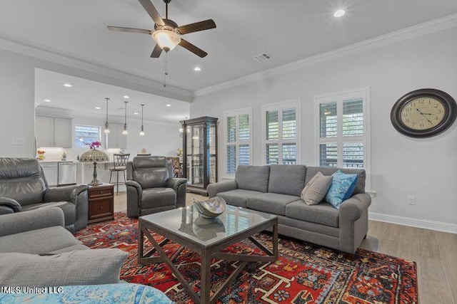 living room with recessed lighting, visible vents, ornamental molding, wood finished floors, and baseboards