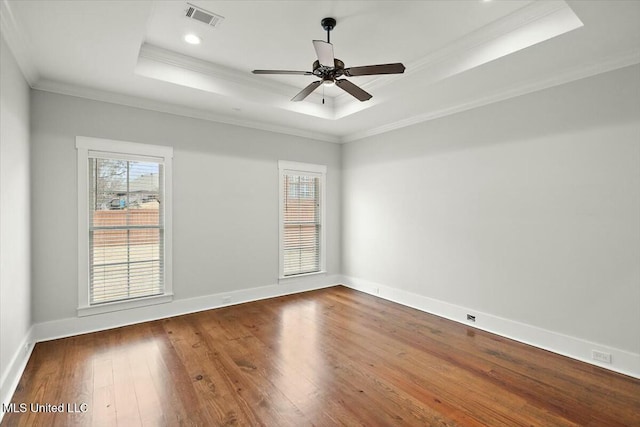 spare room with hardwood / wood-style flooring, crown molding, a healthy amount of sunlight, and a tray ceiling