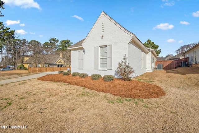 view of side of property featuring cooling unit and a lawn