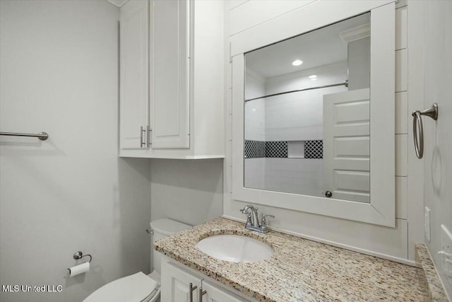 bathroom featuring vanity, walk in shower, and toilet