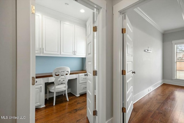 office featuring ornamental molding, dark wood-type flooring, and built in desk