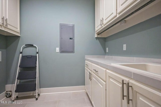 laundry room with light tile patterned floors and electric panel