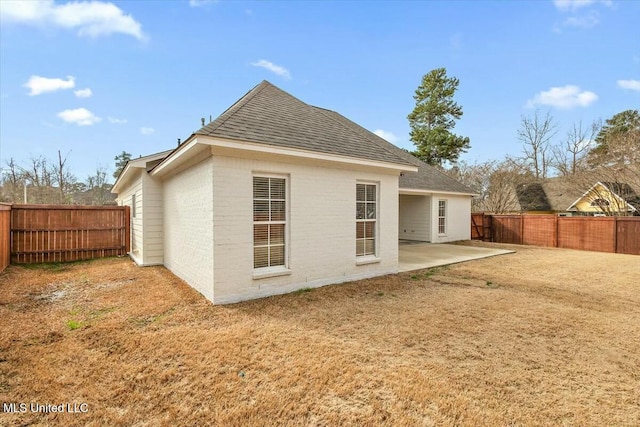 rear view of property with a yard and a patio