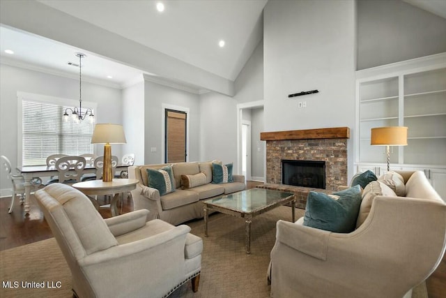 living room with a stone fireplace, a chandelier, high vaulted ceiling, ornamental molding, and hardwood / wood-style flooring