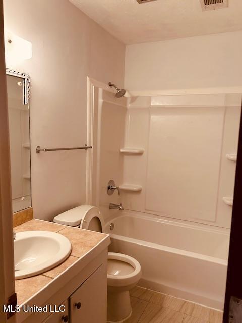 bathroom featuring shower / washtub combination, visible vents, vanity, and toilet