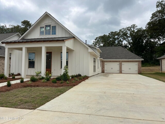 view of front of property with a porch, a garage, and a front lawn