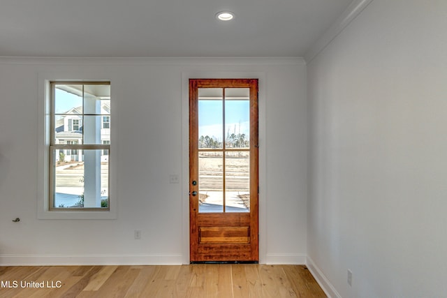 entryway with light wood-type flooring and ornamental molding