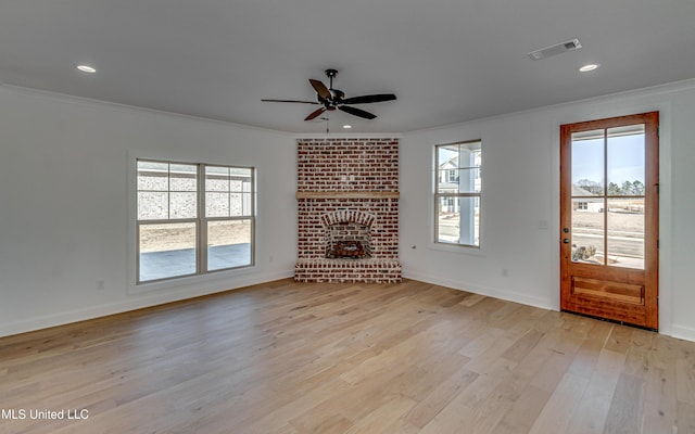 unfurnished living room featuring ceiling fan, light hardwood / wood-style flooring, crown molding, and a fireplace