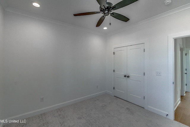 unfurnished bedroom with ceiling fan, light carpet, a closet, and ornamental molding