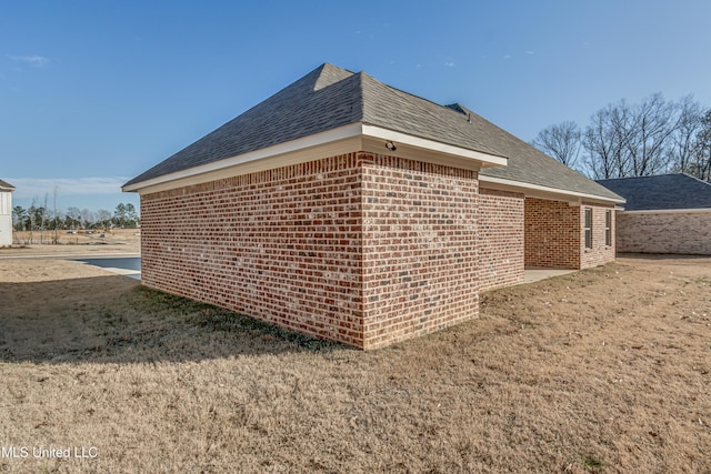 view of side of home with a yard