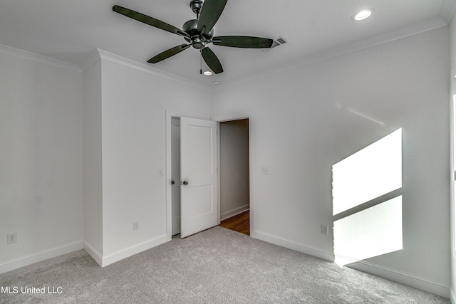 spare room with light carpet, ceiling fan, and crown molding