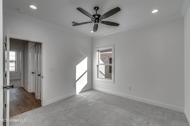 carpeted empty room featuring ceiling fan and ornamental molding