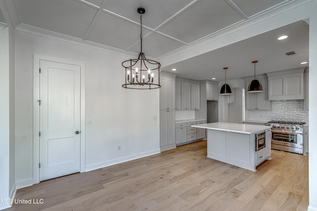 kitchen featuring pendant lighting, tasteful backsplash, a kitchen island, light hardwood / wood-style floors, and stainless steel appliances