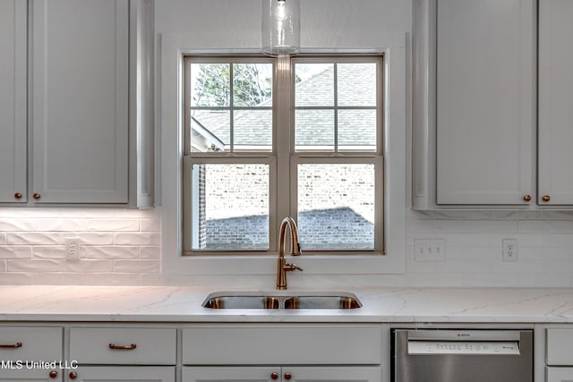 kitchen with sink, backsplash, light stone countertops, and stainless steel dishwasher