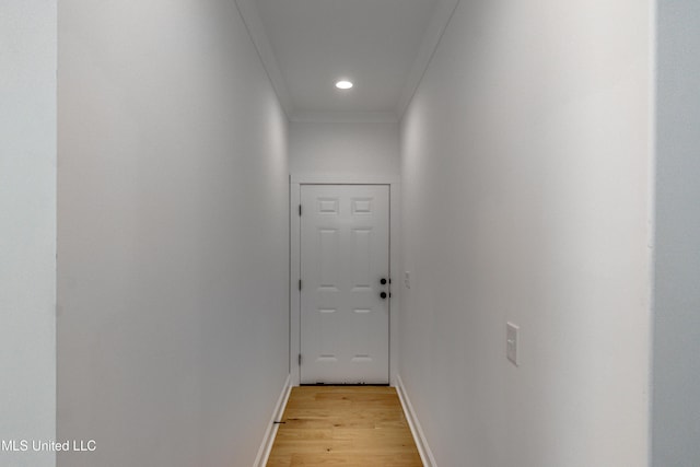 corridor with light hardwood / wood-style flooring and crown molding