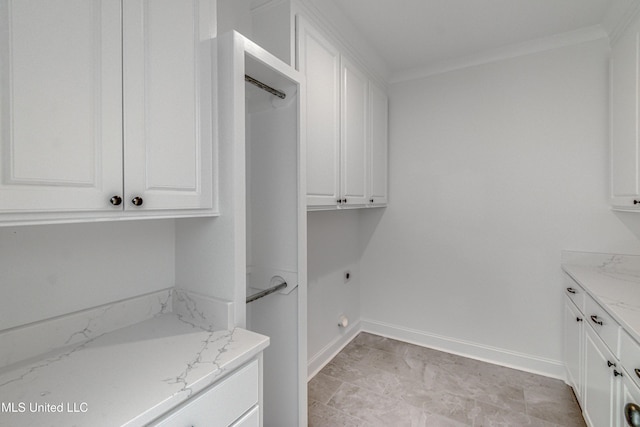 clothes washing area with hookup for an electric dryer, cabinets, and crown molding