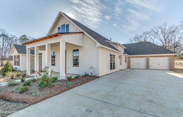 603 Cobalt Way, Brandon, MS 39042 - view of front facade with concrete driveway, board and batten siding, a porch, a garage, and roof with shingles