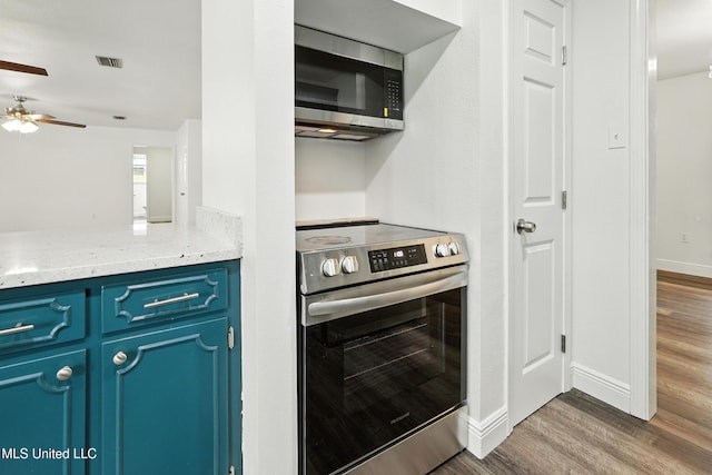 611 E E Lakeshore Dr, Carriere, MS 39426 - kitchen featuring appliances with stainless steel finishes, blue cabinetry, wood finished floors, and a ceiling fan