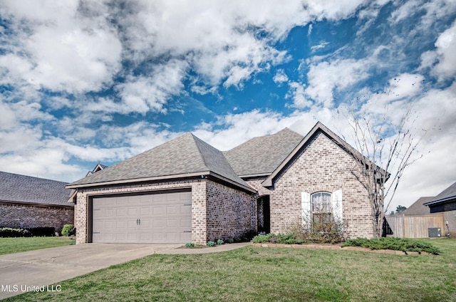 french country home with brick siding, a front lawn, fence, concrete driveway, and an attached garage