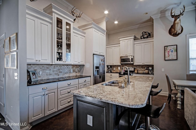 kitchen with crown molding, baseboards, decorative backsplash, appliances with stainless steel finishes, and a sink