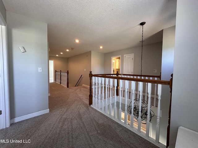 hallway with carpet floors and a textured ceiling