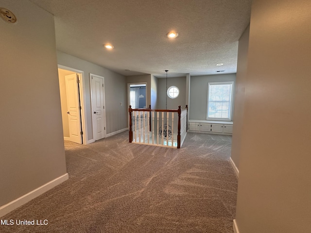 corridor featuring carpet and a textured ceiling