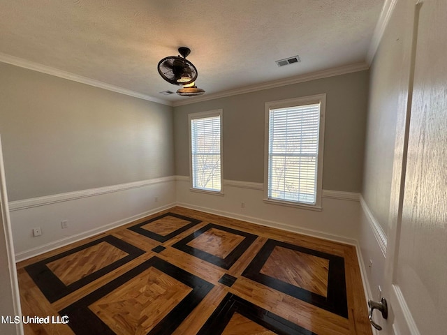 unfurnished room with a textured ceiling and ornamental molding