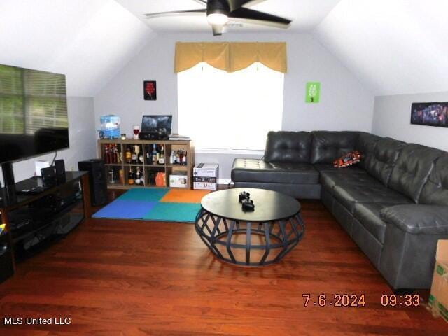 living room featuring dark wood-type flooring, ceiling fan, and lofted ceiling