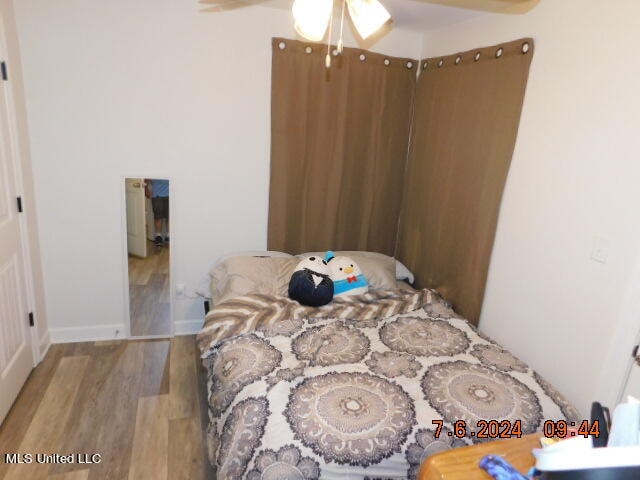 bedroom with wood-type flooring and ceiling fan