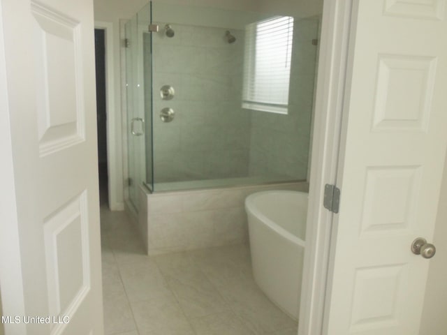 7156 Edgewater Dr, Olive Branch, MS 38654 - full bath featuring tile patterned flooring, a shower stall, and a freestanding tub