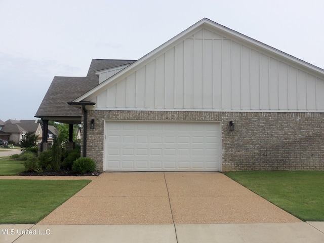 7156 Edgewater Dr, Olive Branch, MS 38654 - view of front of property with brick siding, driveway, an attached garage, a shingled roof, and board and batten siding