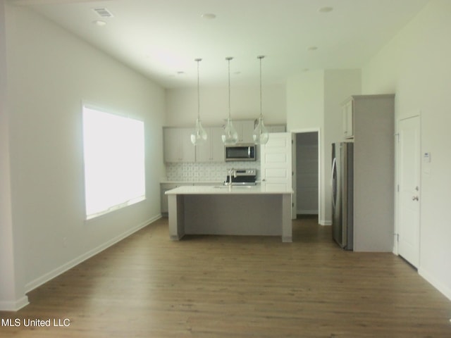 7156 Edgewater Dr, Olive Branch, MS 38654 - kitchen featuring appliances with stainless steel finishes, light countertops, wood finished floors, backsplash, and hanging light fixtures