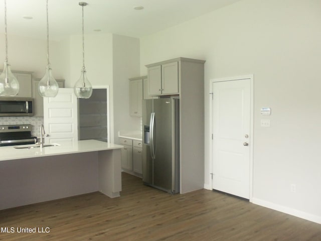 7156 Edgewater Dr, Olive Branch, MS 38654 - kitchen with stainless steel appliances, a sink, gray cabinets, tasteful backsplash, and dark wood finished floors