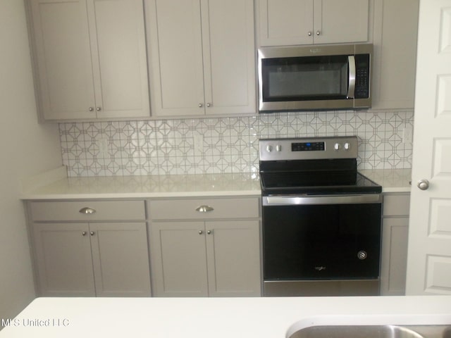 7156 Edgewater Dr, Olive Branch, MS 38654 - kitchen featuring appliances with stainless steel finishes, light countertops, and tasteful backsplash