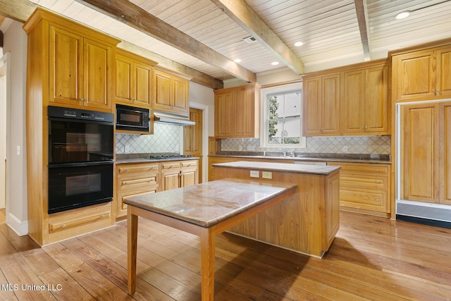 kitchen featuring a center island, tasteful backsplash, light hardwood / wood-style flooring, beamed ceiling, and black appliances