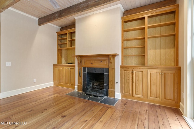 unfurnished living room with wooden ceiling, beamed ceiling, light wood-type flooring, a fireplace, and ornamental molding