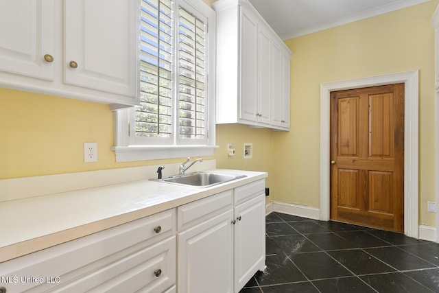 kitchen featuring white cabinetry, sink, dark tile patterned floors, and crown molding