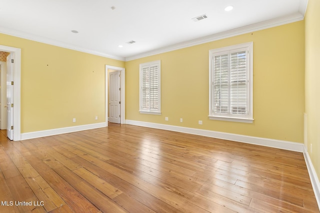 empty room featuring light wood-type flooring and ornamental molding