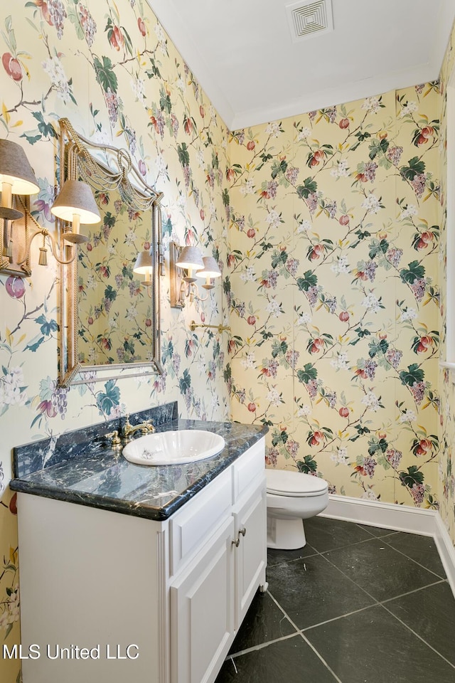 bathroom with tile patterned flooring, vanity, ornamental molding, and toilet