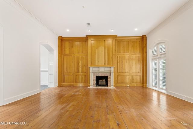 unfurnished living room with a fireplace, light hardwood / wood-style flooring, and crown molding