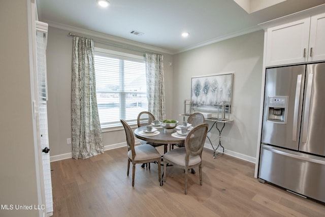 dining room featuring ornamental molding and light hardwood / wood-style flooring