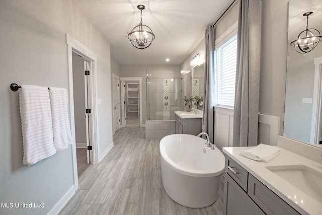 bathroom featuring vanity, separate shower and tub, and a chandelier