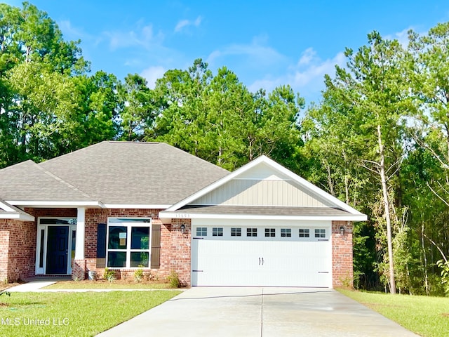 15693 Perdido Dr, Gulfport, MS 39503 - view of front of house with a shingled roof, a front lawn, concrete driveway, an attached garage, and brick siding
