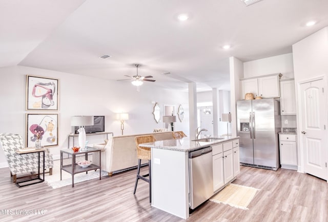 15693 Perdido Dr, Gulfport, MS 39503 - kitchen with light stone counters, light wood-type flooring, appliances with stainless steel finishes, and ceiling fan