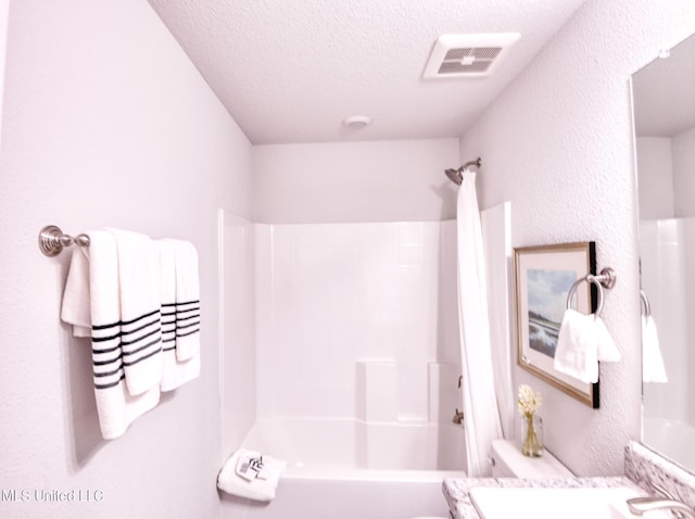15693 Perdido Dr, Gulfport, MS 39503 - bathroom with washtub / shower combination, visible vents, toilet, vanity, and a textured ceiling